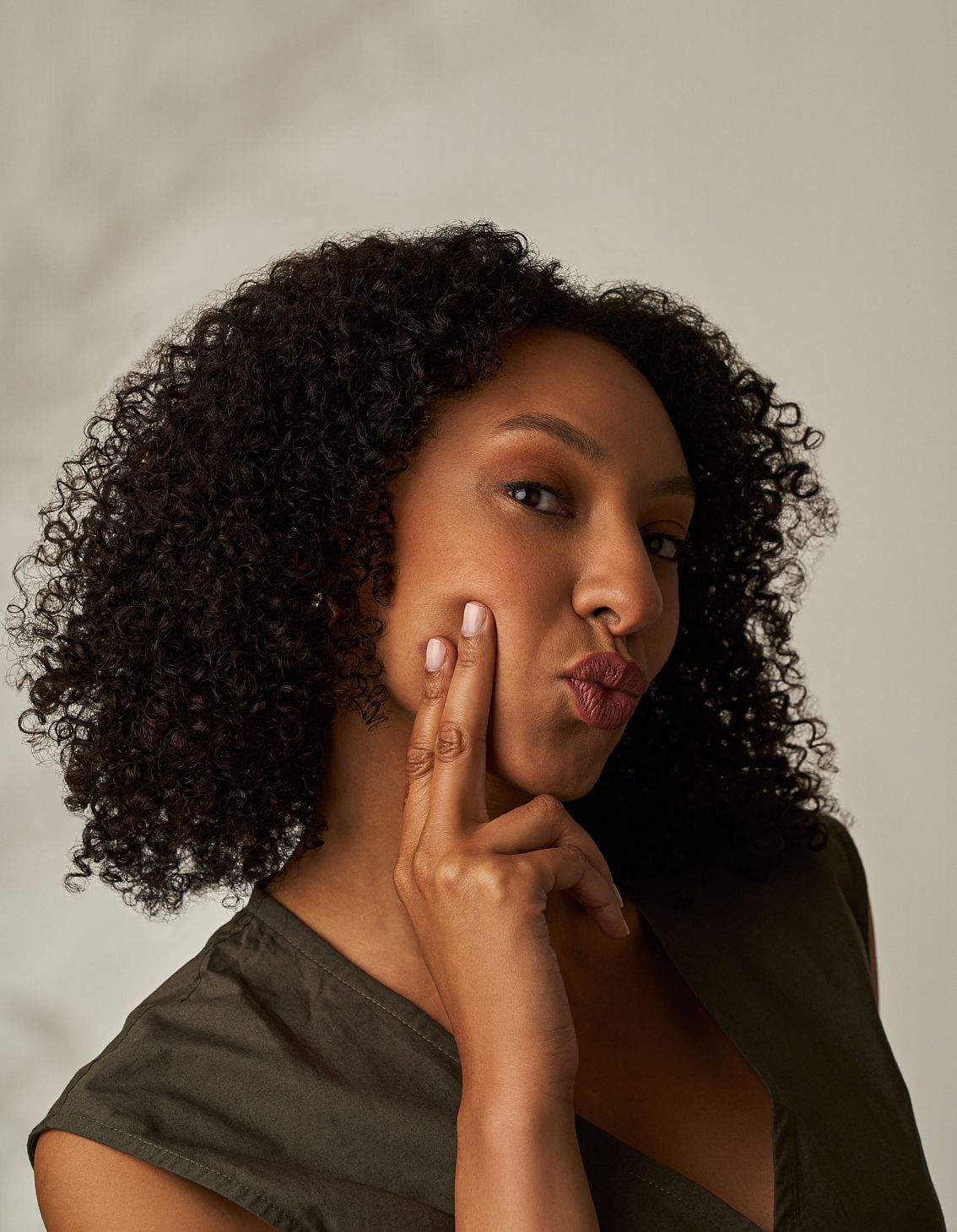 Eine Frau hält ihr Gesicht mit ihren Händen und lächelt. Hyaluron