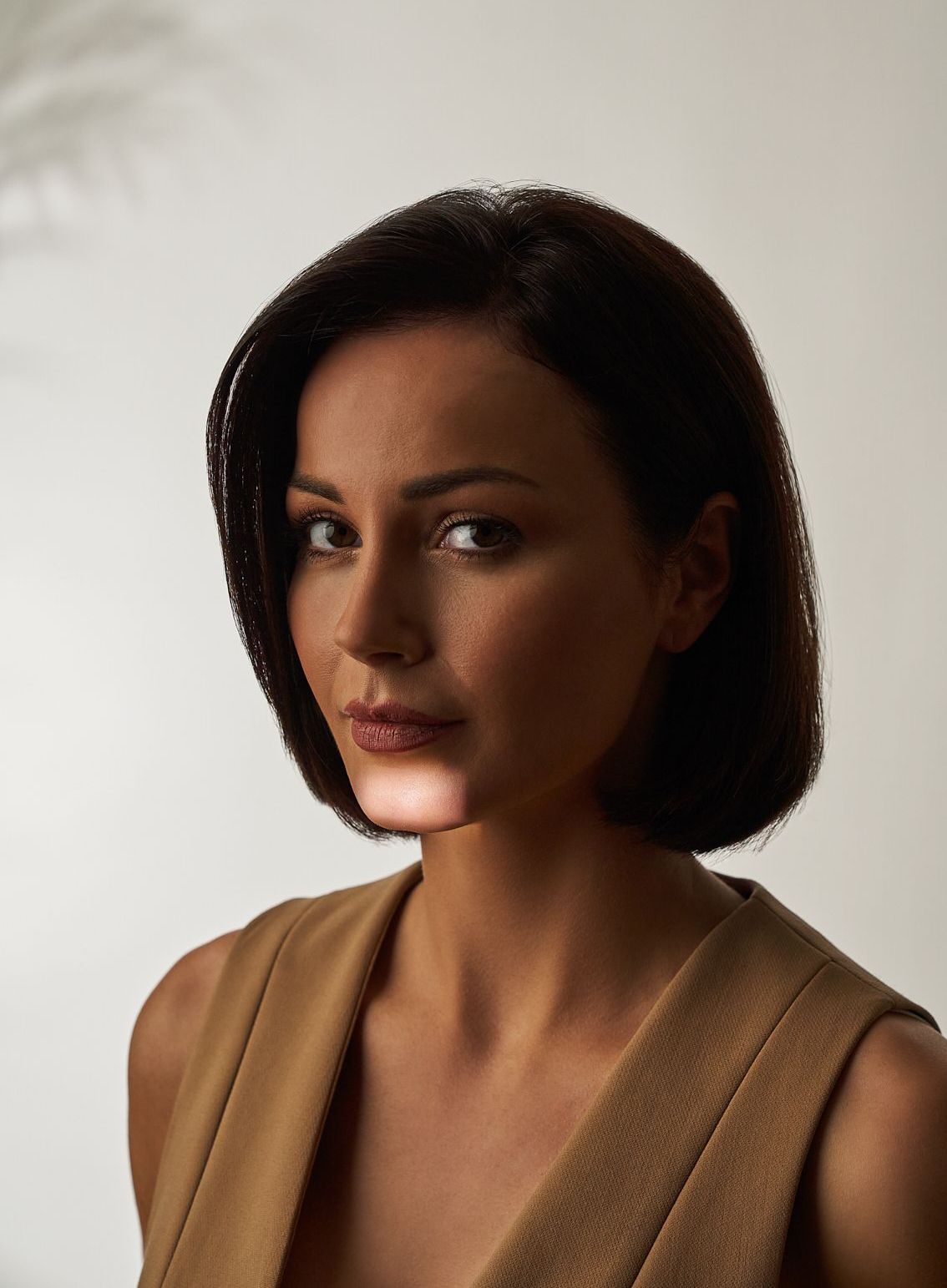 Eine Frau ohne Hemd lächelt mit ihrer Hand auf ihre Wange. Hyaluron