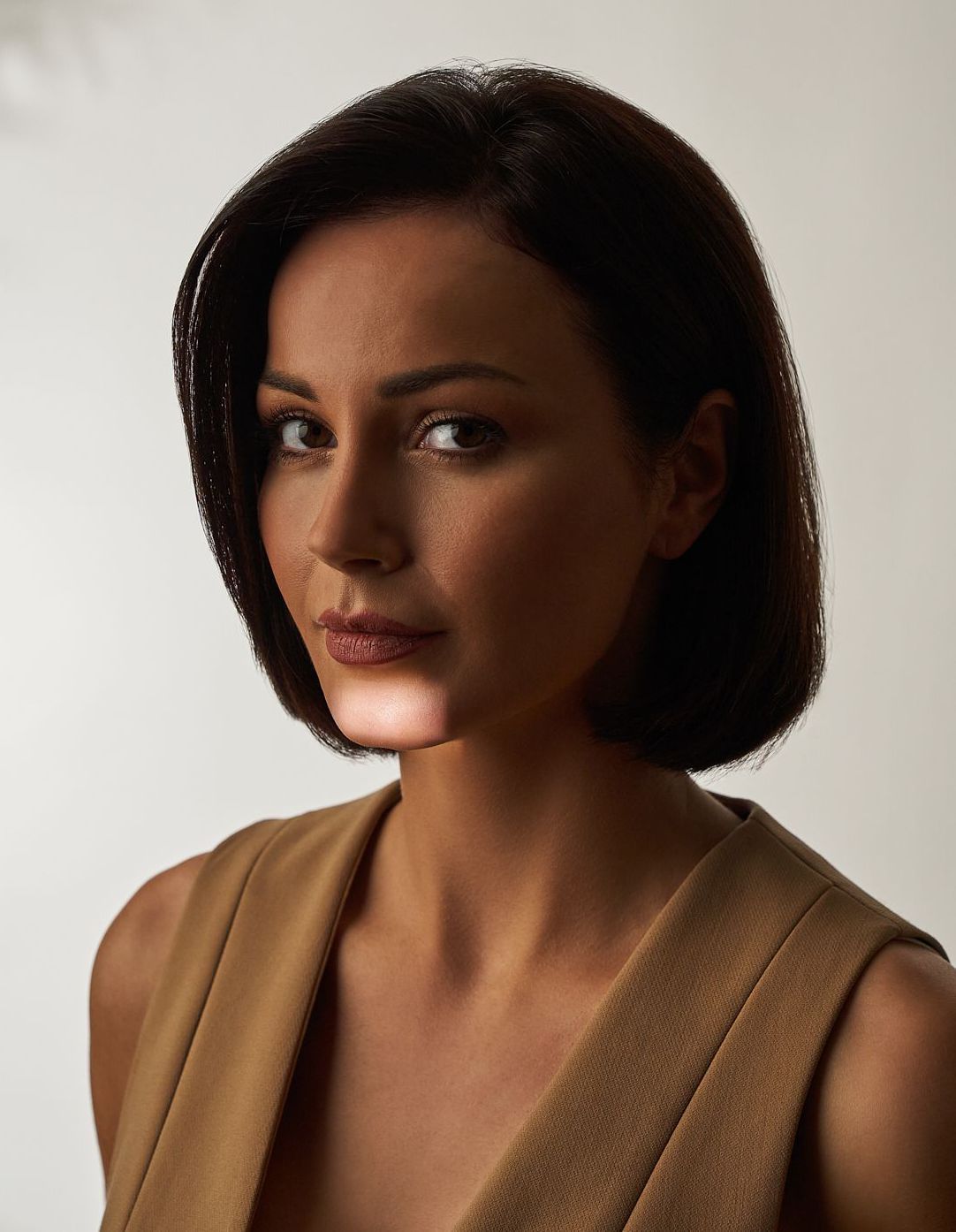 eine Frau mit langen Haaren und roten Lippen schaut in die Kamera ERDBEERKINN. Muskelrelaxans botox Behandlung 