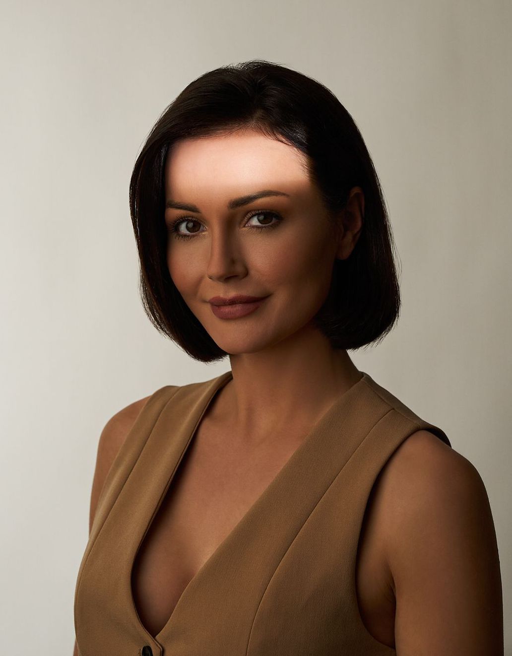 Eine Frau hält ihr Gesicht mit der Hand und schaut in die Kamera. Muskelrelaxans