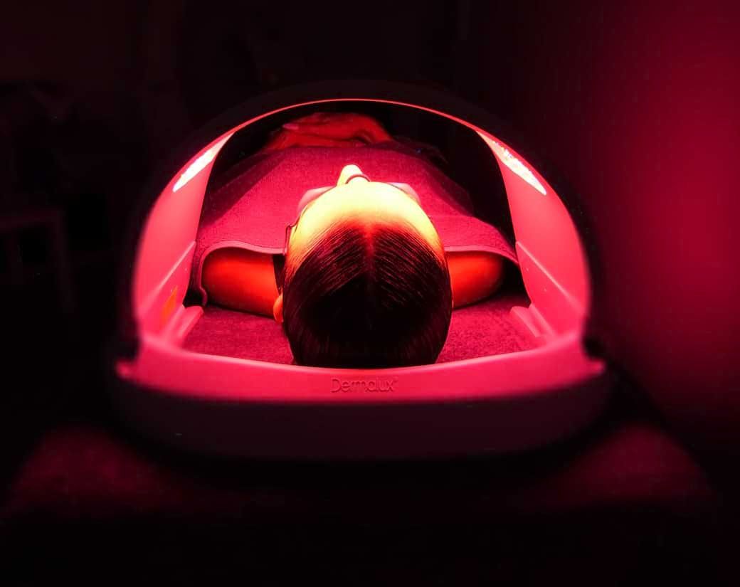 Eine Person liegt unter einer roten Ampel