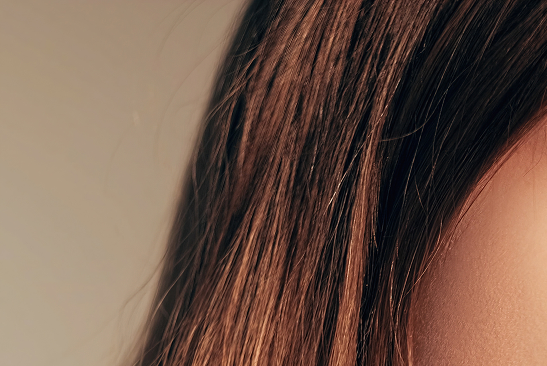 Nahaufnahme des Ohrs einer Frau mit lockigem Haar. Home