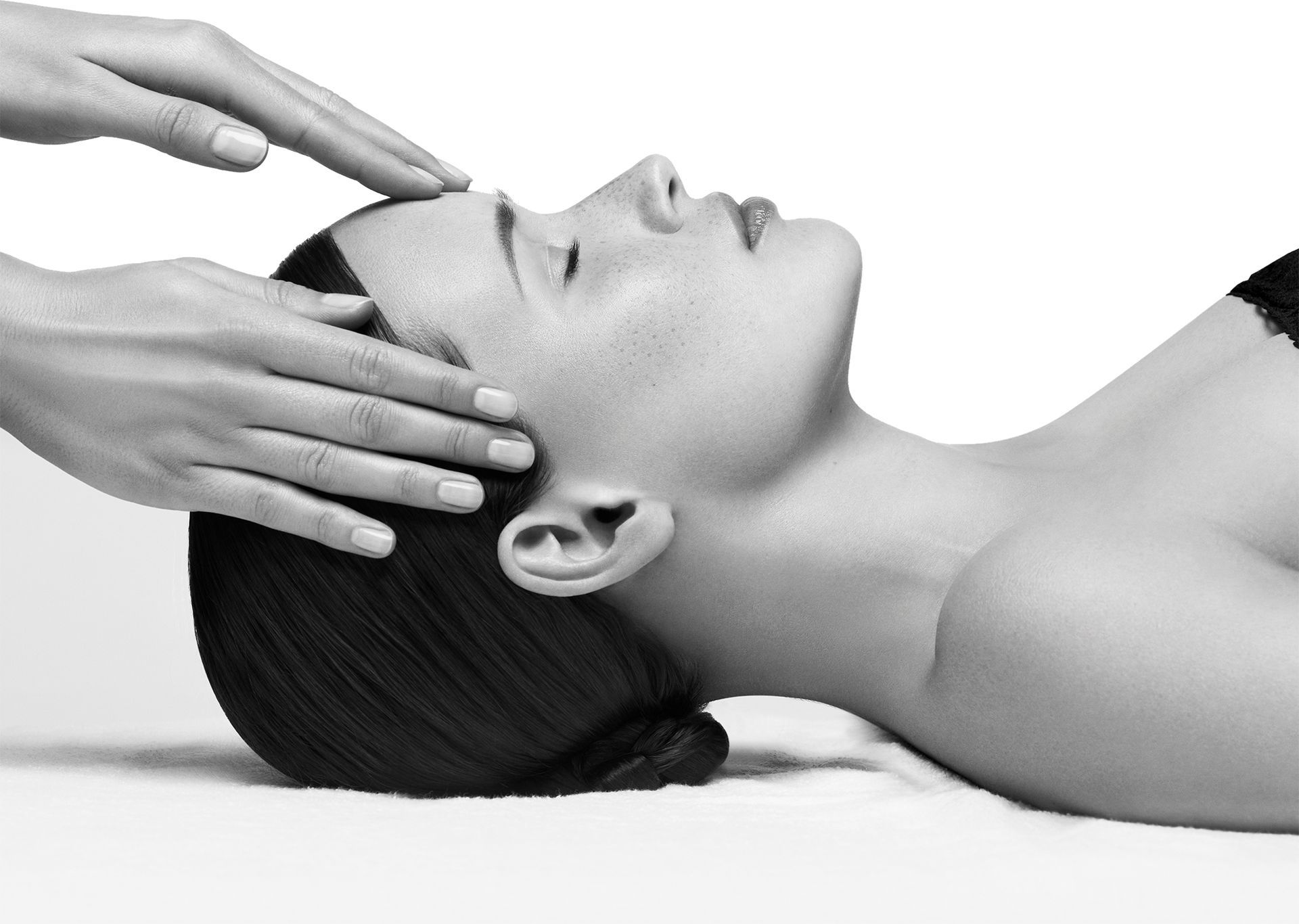 Ein Schwarzweißfoto einer Frau, die eine Kopfmassage bekommt