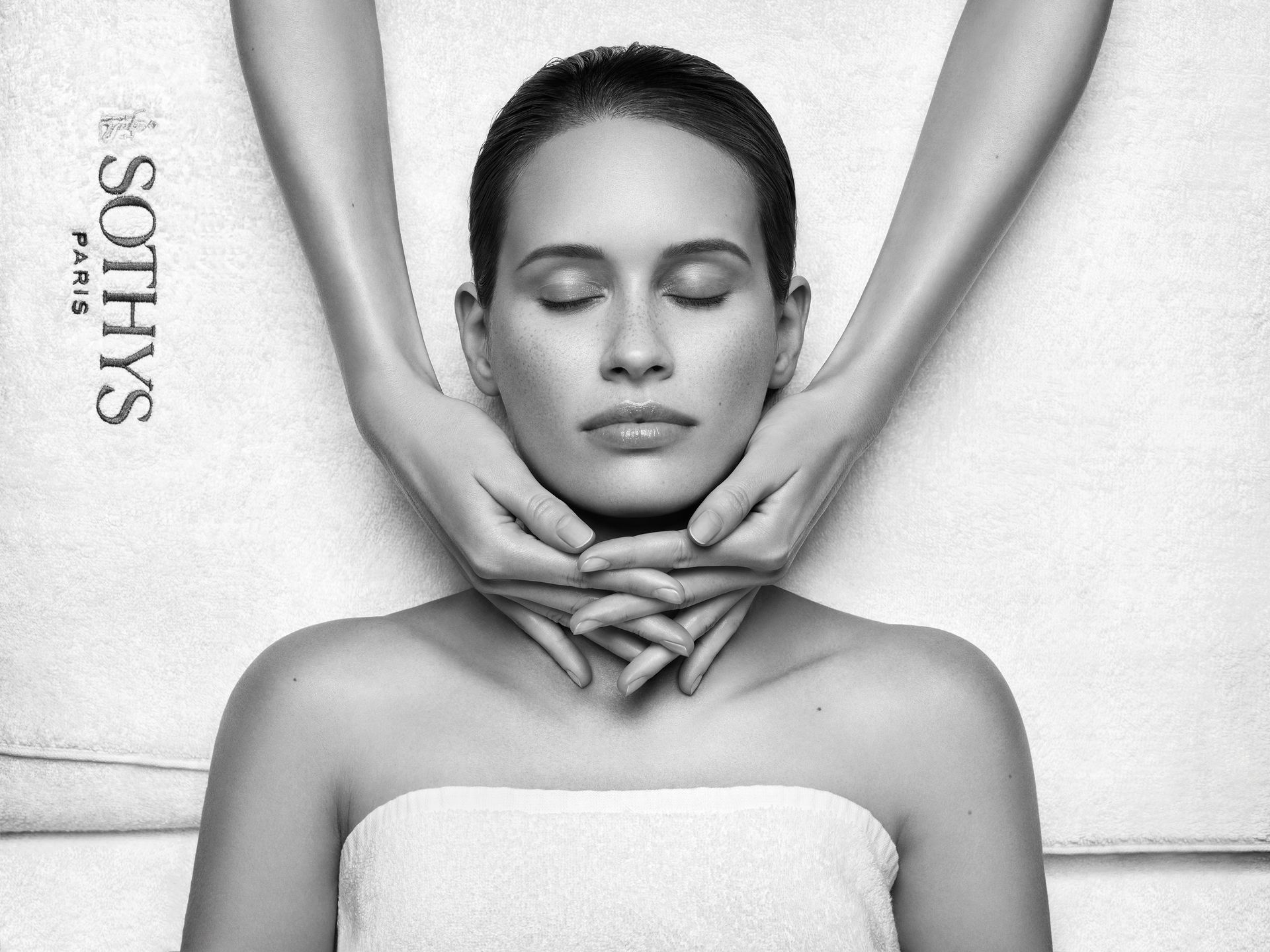 Eine Frau ohne Hemd lächelt mit ihrer Hand auf ihre Wange. Hyaluron