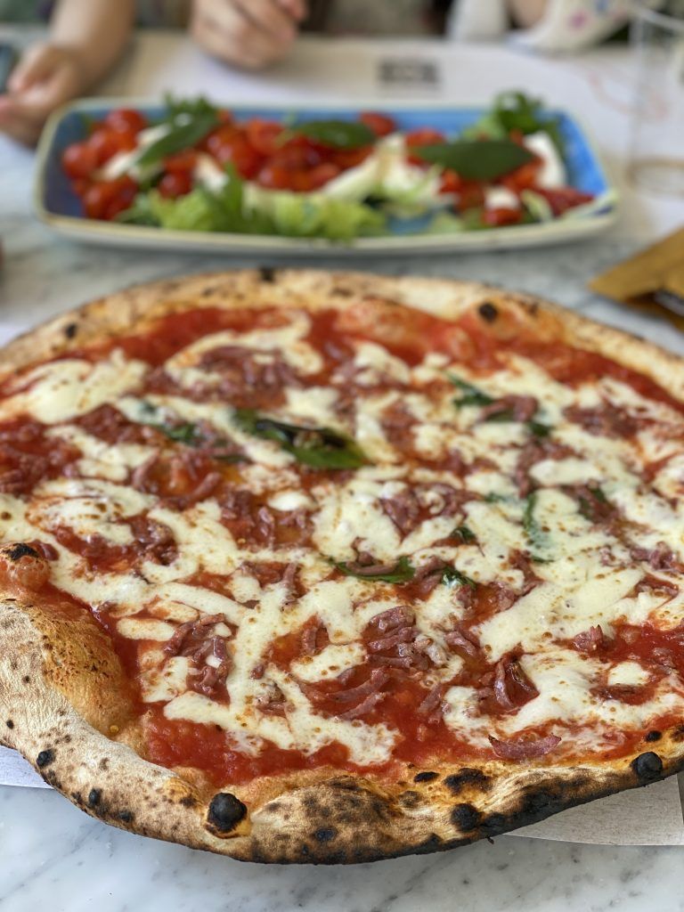 Pizza e insalata caprese su un tavolo in un ristorante.