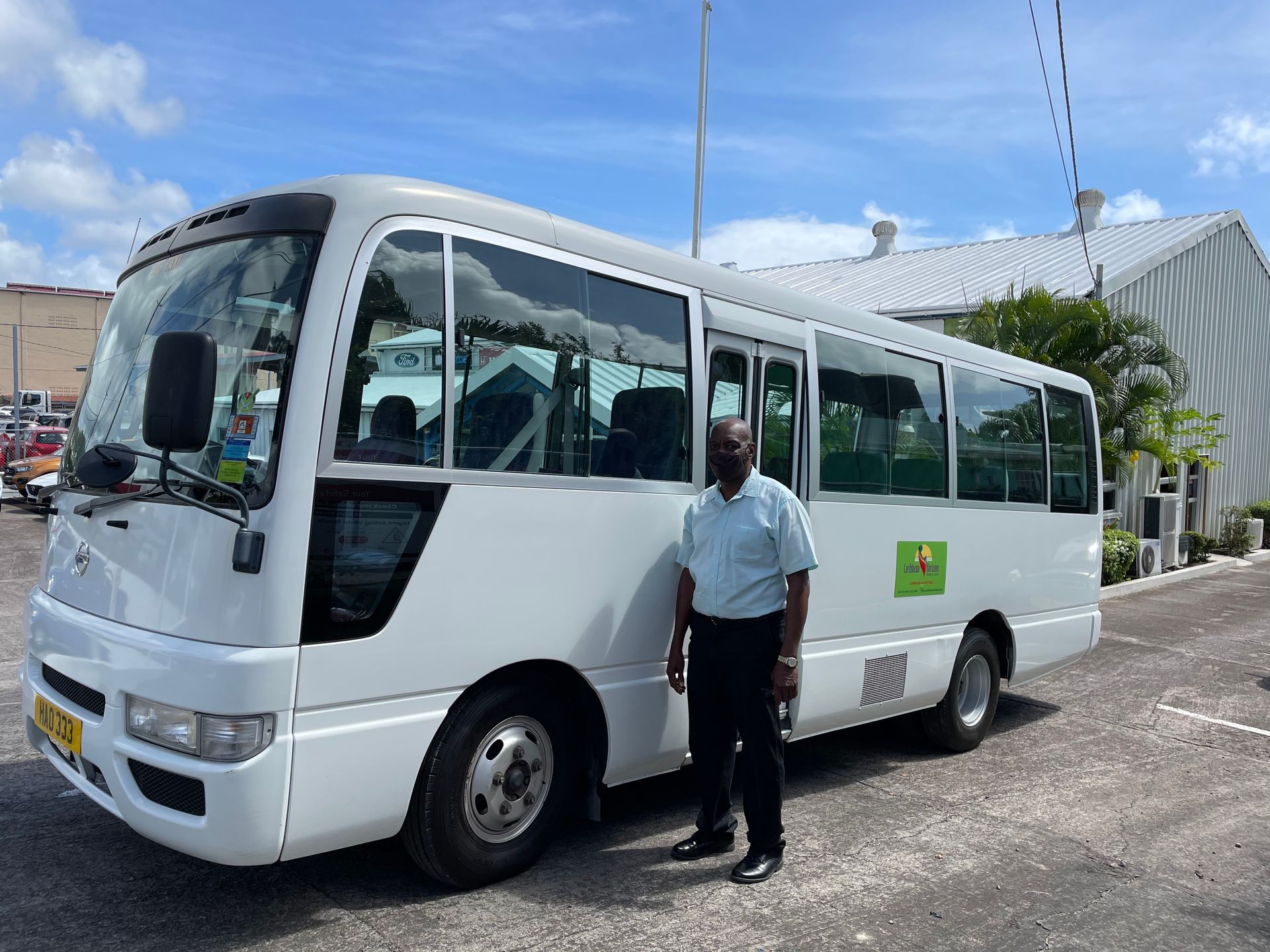A man stands in front of a white bus with the number 992 on the side