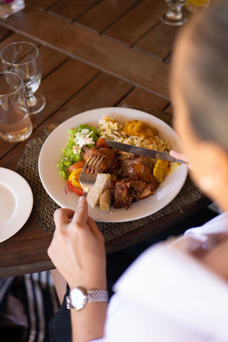 A person is sitting at a table eating a plate of food.