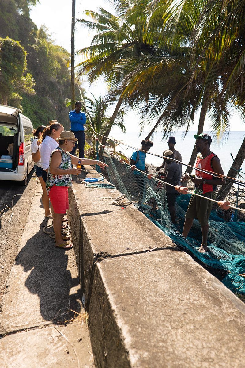 A group of people are standing next to a fishing net.