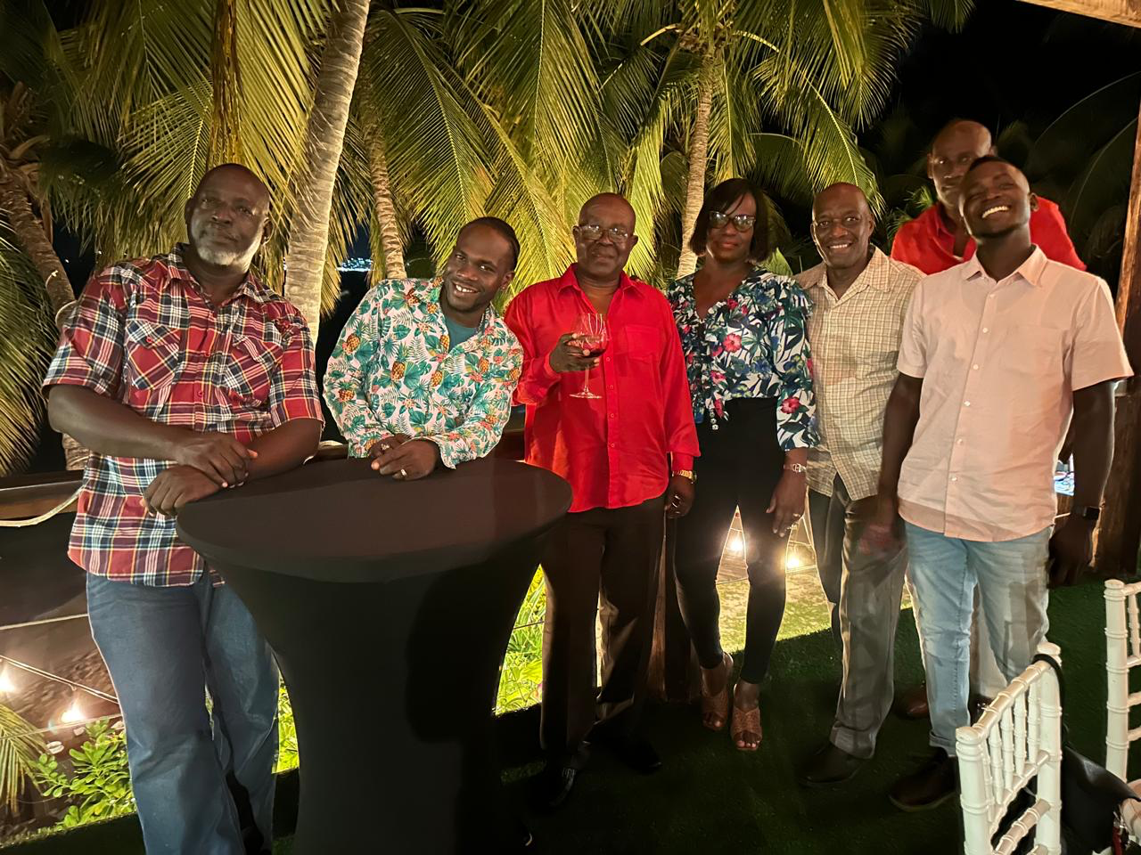 A group of people are posing for a picture while standing around a table.