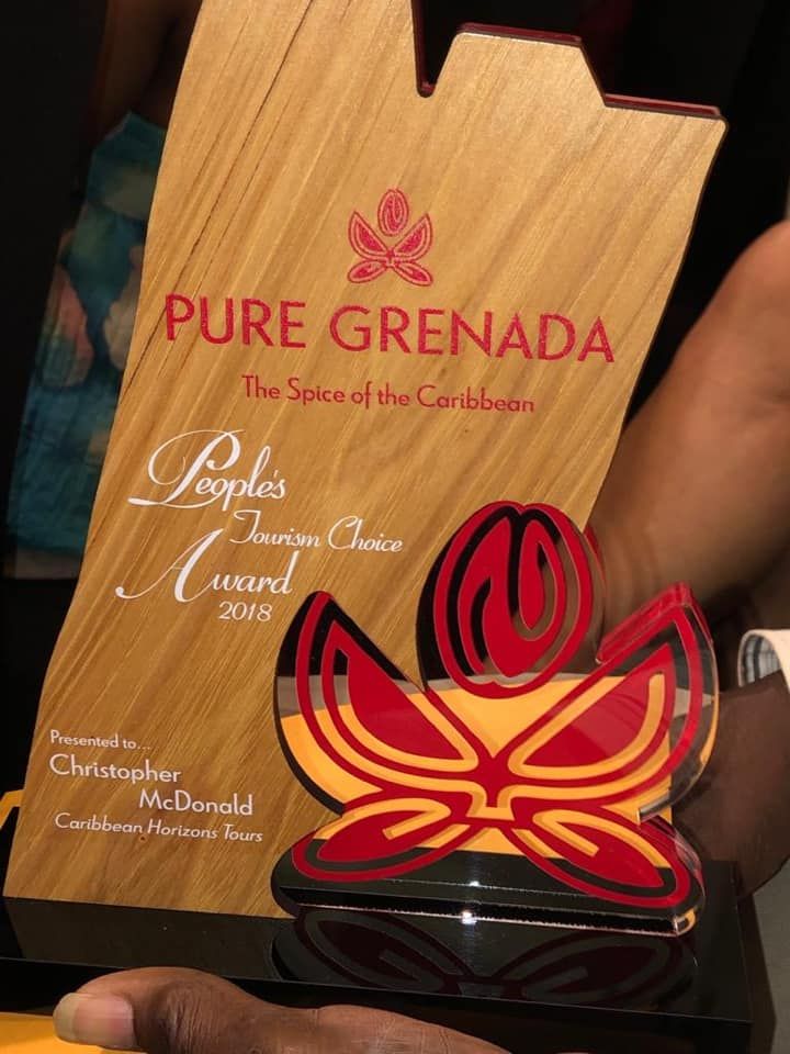 A person is holding a trophy that says pure grenada
