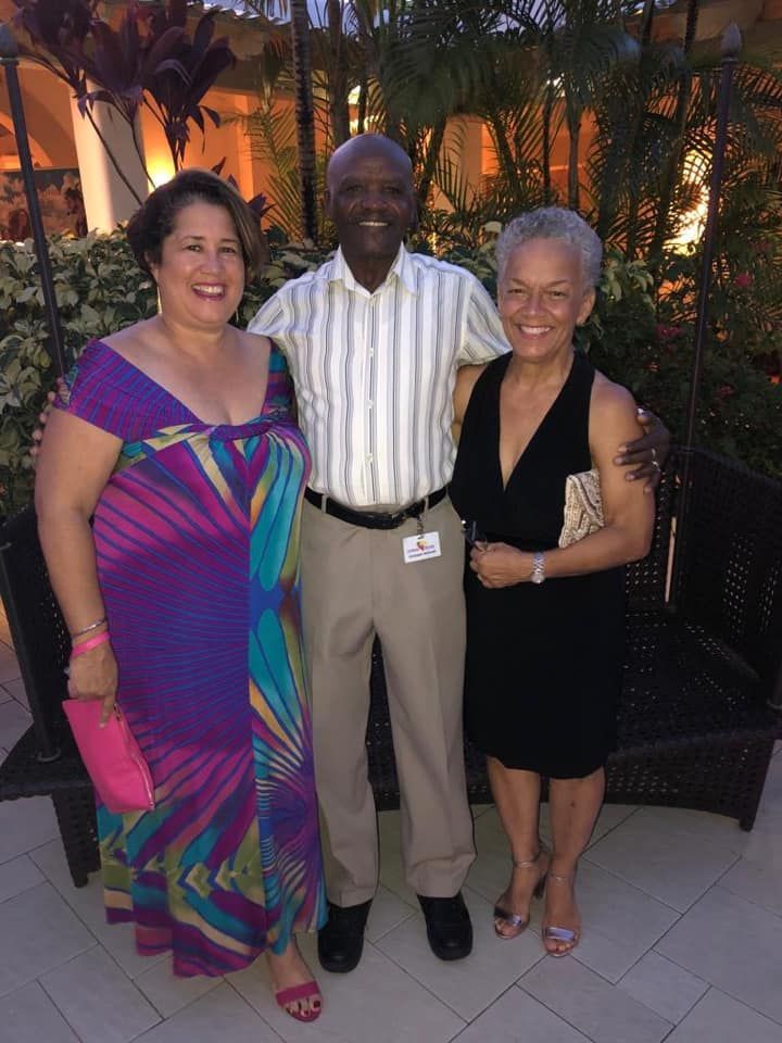 A man and two women are posing for a picture