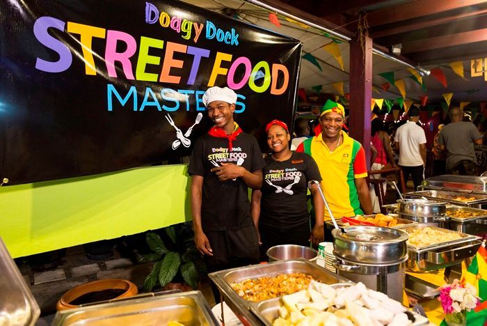 A group of people standing in front of a sign that says street food masters