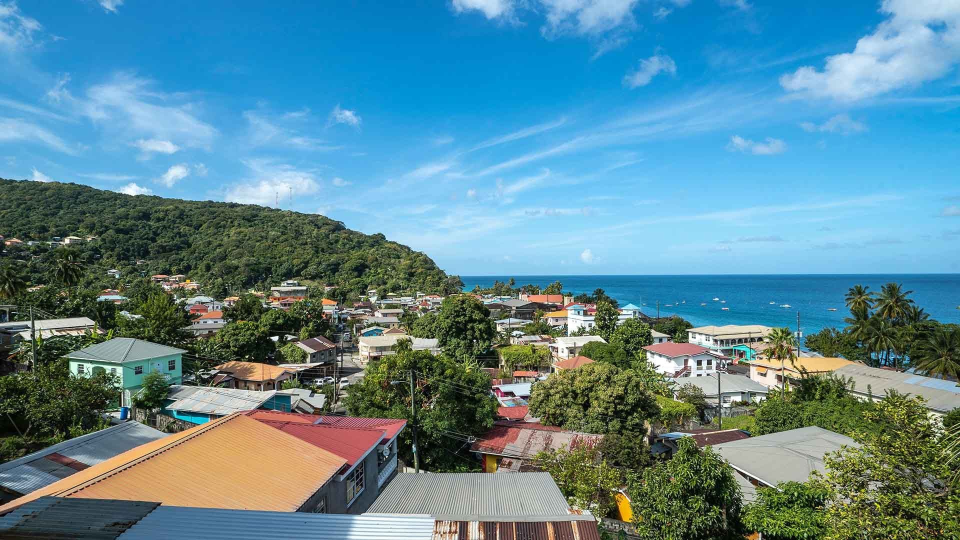 An aerial view of a small town on a hill overlooking the ocean.