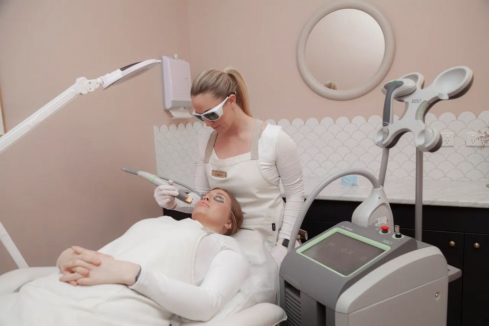 Woman Receiving Laser Treatment on Her Face by a Technician in a Medical Office — Eternal Radiance in Strathmore, VIC