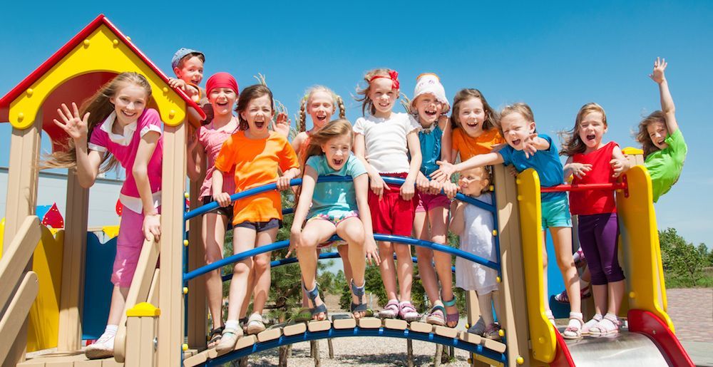 a group of children are posing for a picture on a playground .