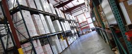 A large warehouse filled with lots of boxes on shelves.