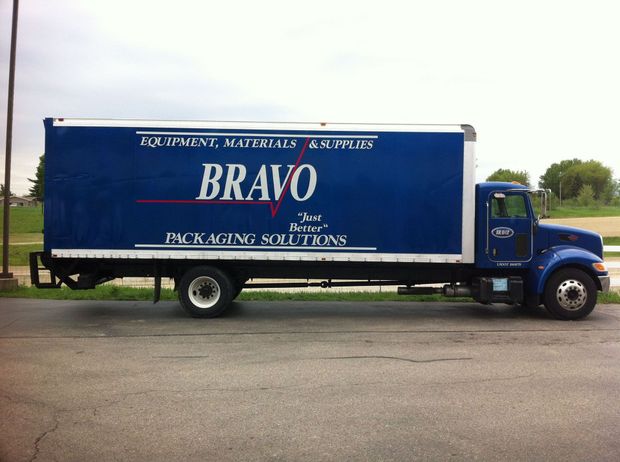 A blue bravo truck is parked on the side of the road