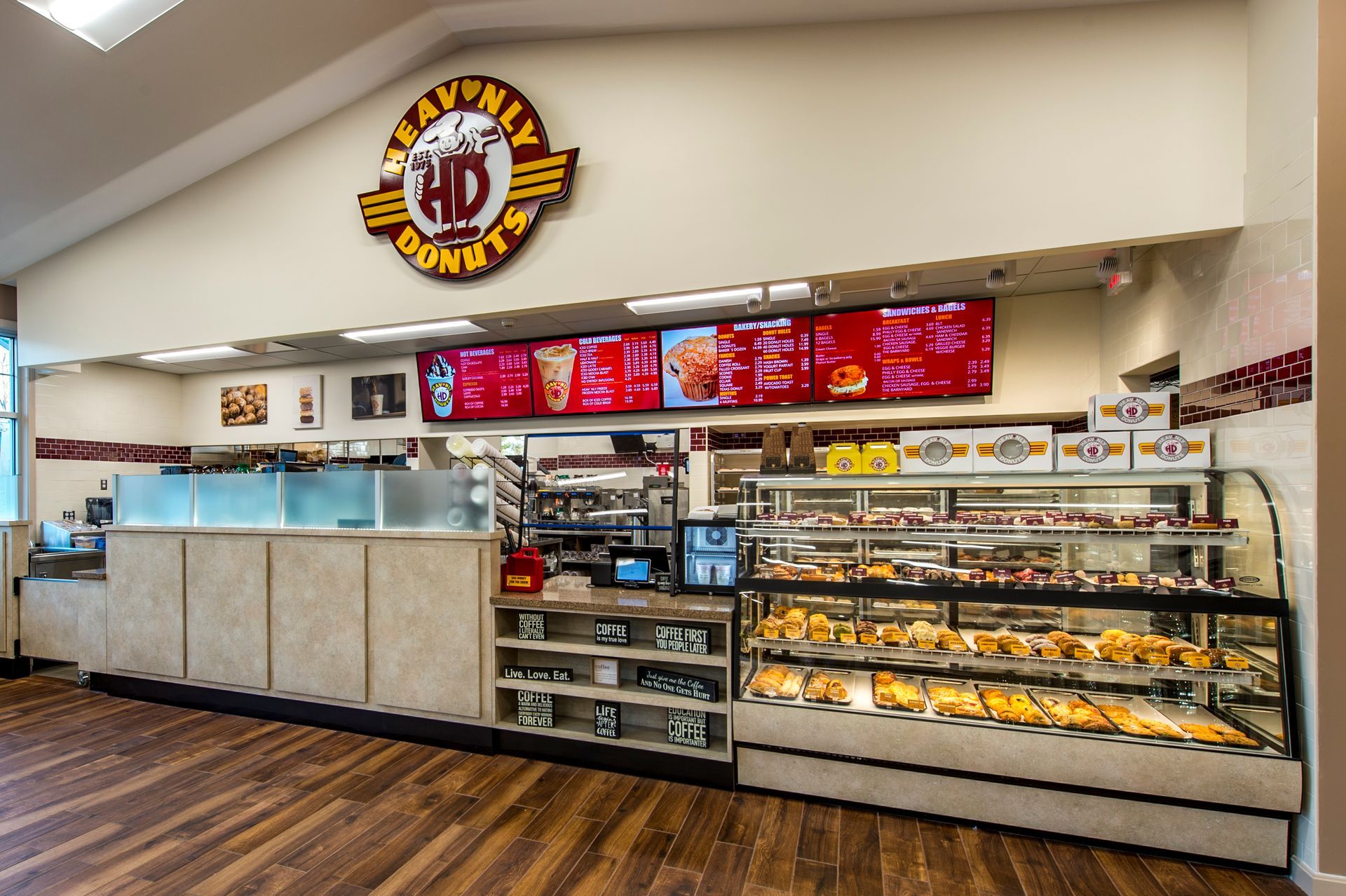 Interior of Heavenly Donuts shop, display cases filled with pastries, menu boards, counter, logo sign.
