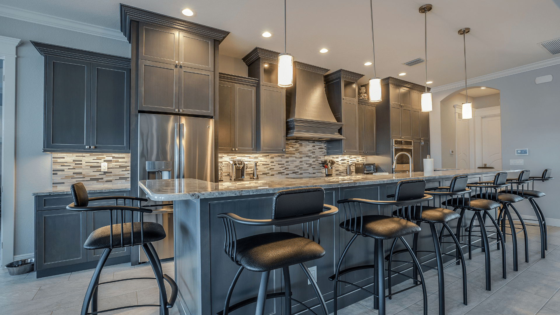 A kitchen with a large island and bar stools.
