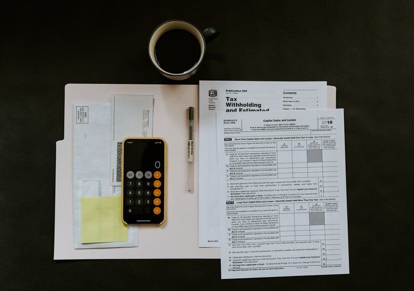 A calculator is sitting on a desk next to a cup of coffee