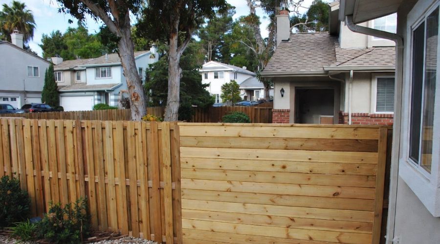Wooden fence separating yards in a residential neighborhood.