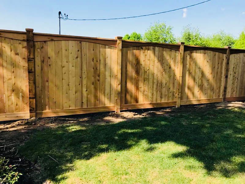 A wooden fence is sitting on top of a lush green lawn.