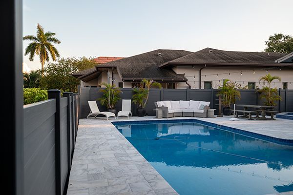 There is a large swimming pool in the backyard of a house.