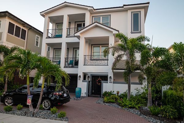 A large white house with a car parked in front of it