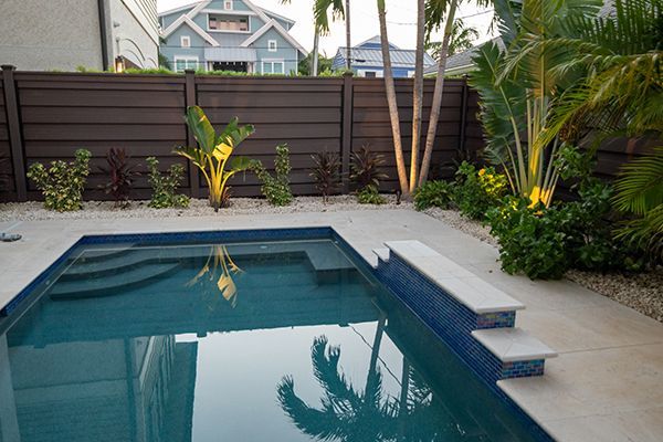 A large swimming pool with a wooden fence surrounding it