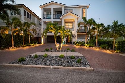 A large white house with palm trees in front of it