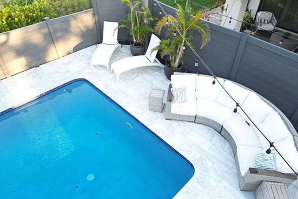 An aerial view of a swimming pool with a couch and chairs around it.