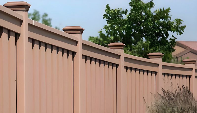 A brown wooden fence with a tree in the background