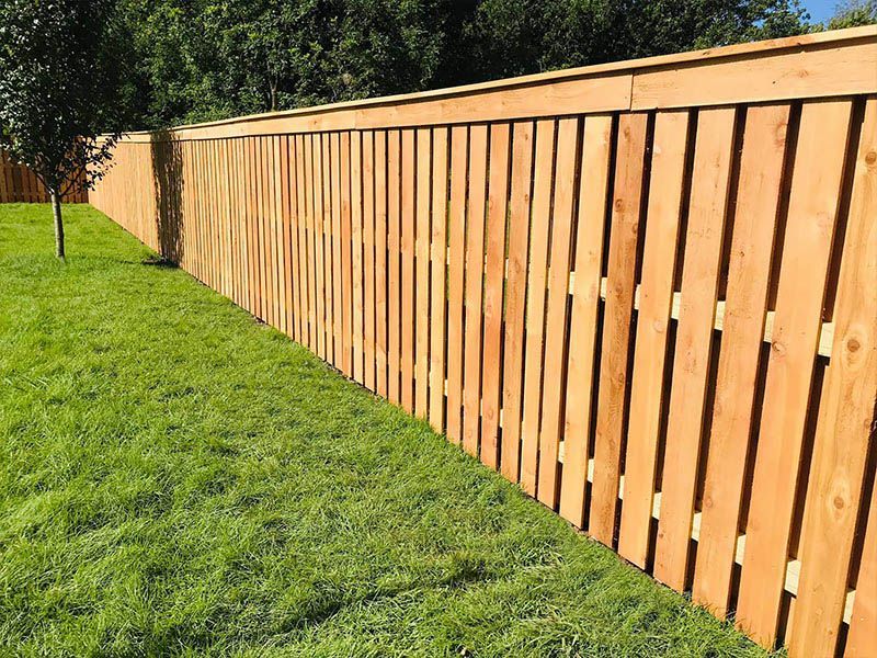 A wooden fence is sitting on top of a lush green lawn.