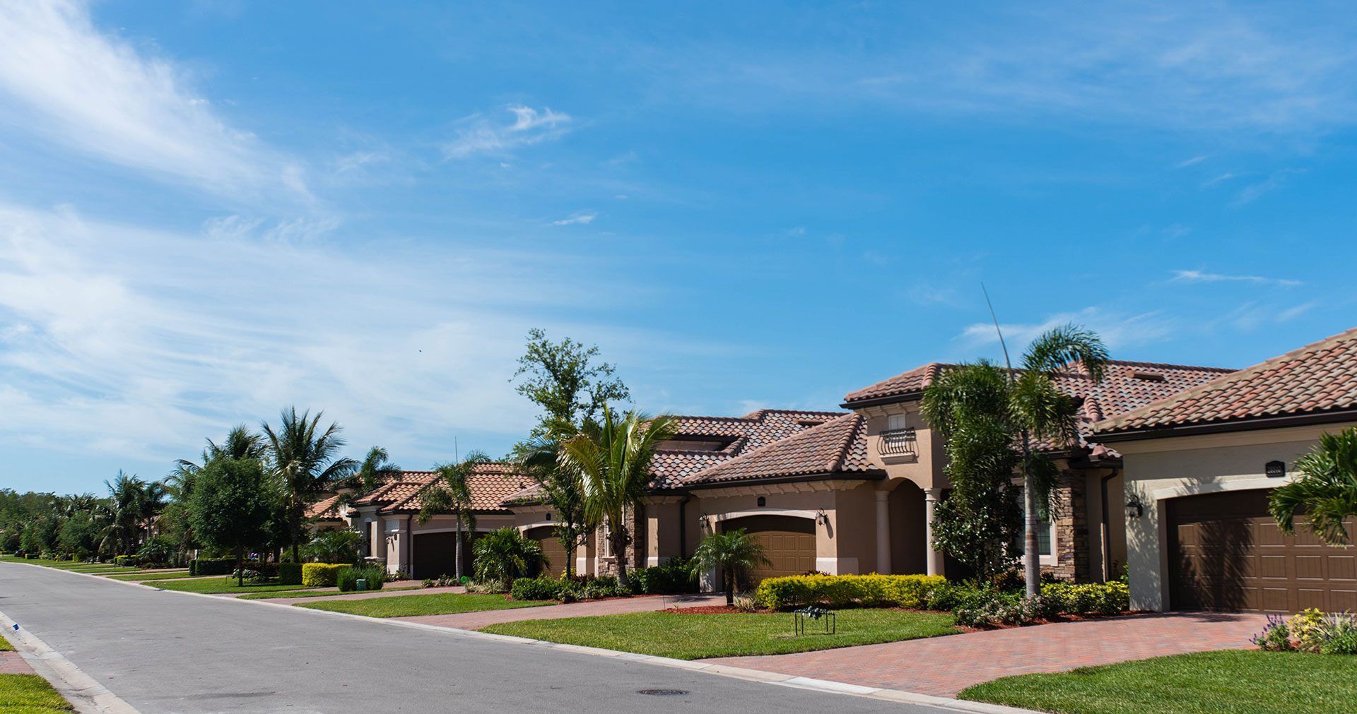 A row of houses on a sunny day with a blue sky in the background.