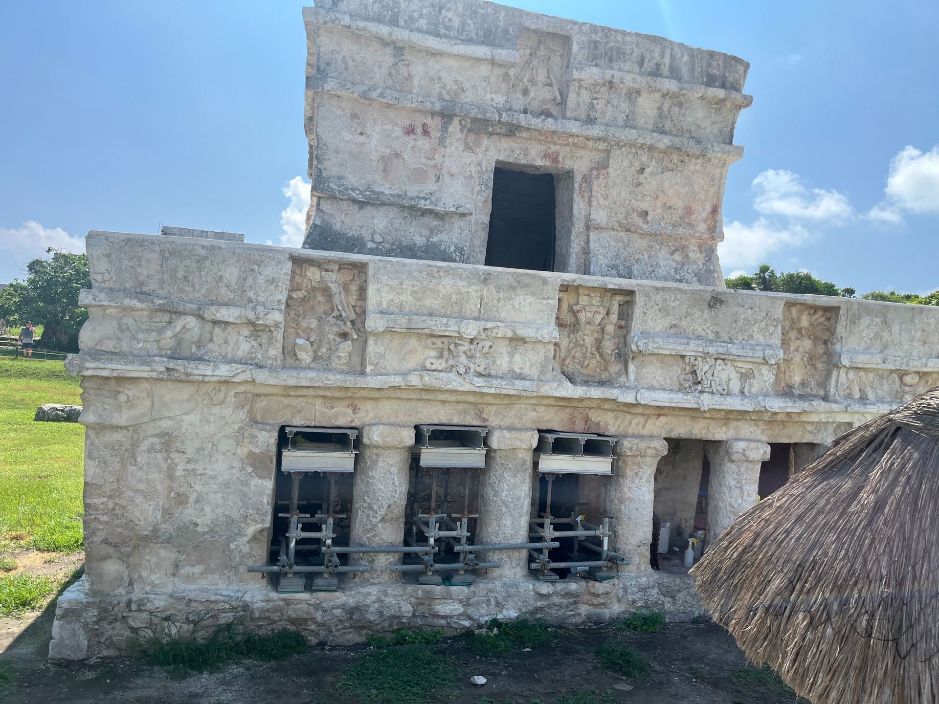 Ancient stone Mayan ruins against a bright blue sky.