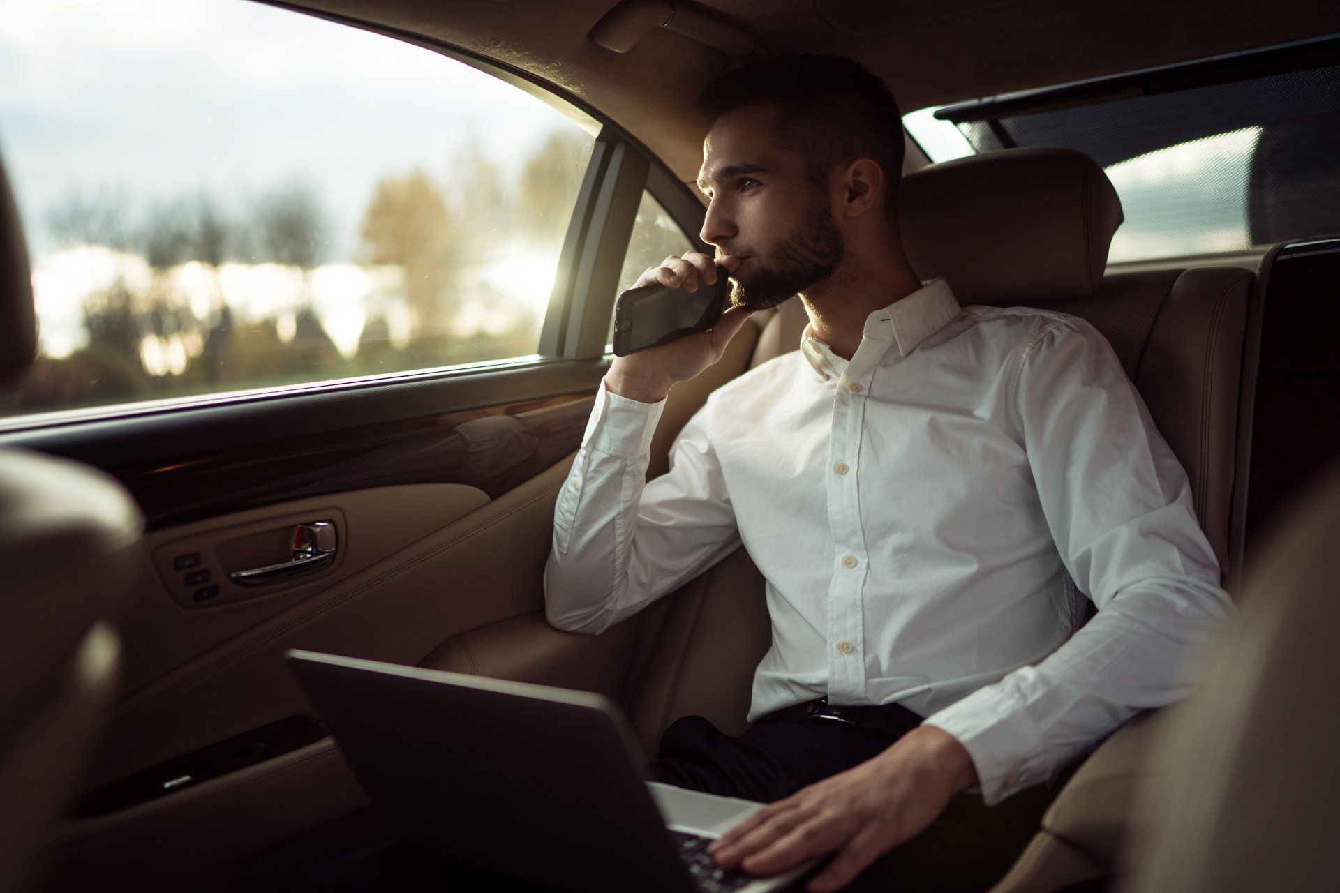 Man looking away while sitting on the back seat of a car, businessman in taxi
