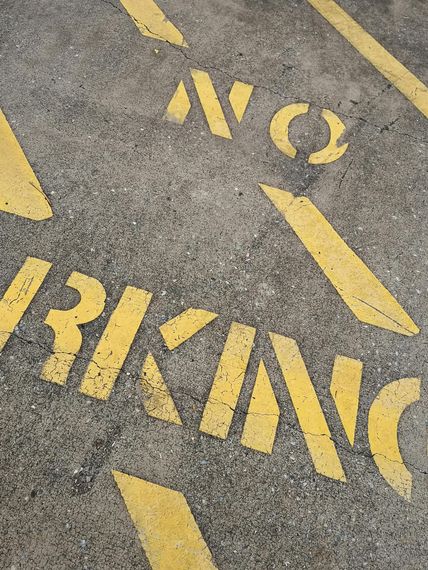 older faded parking lot with yellow striping and marking 