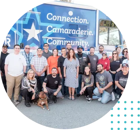 Group of people posing in front of a blue truck with 