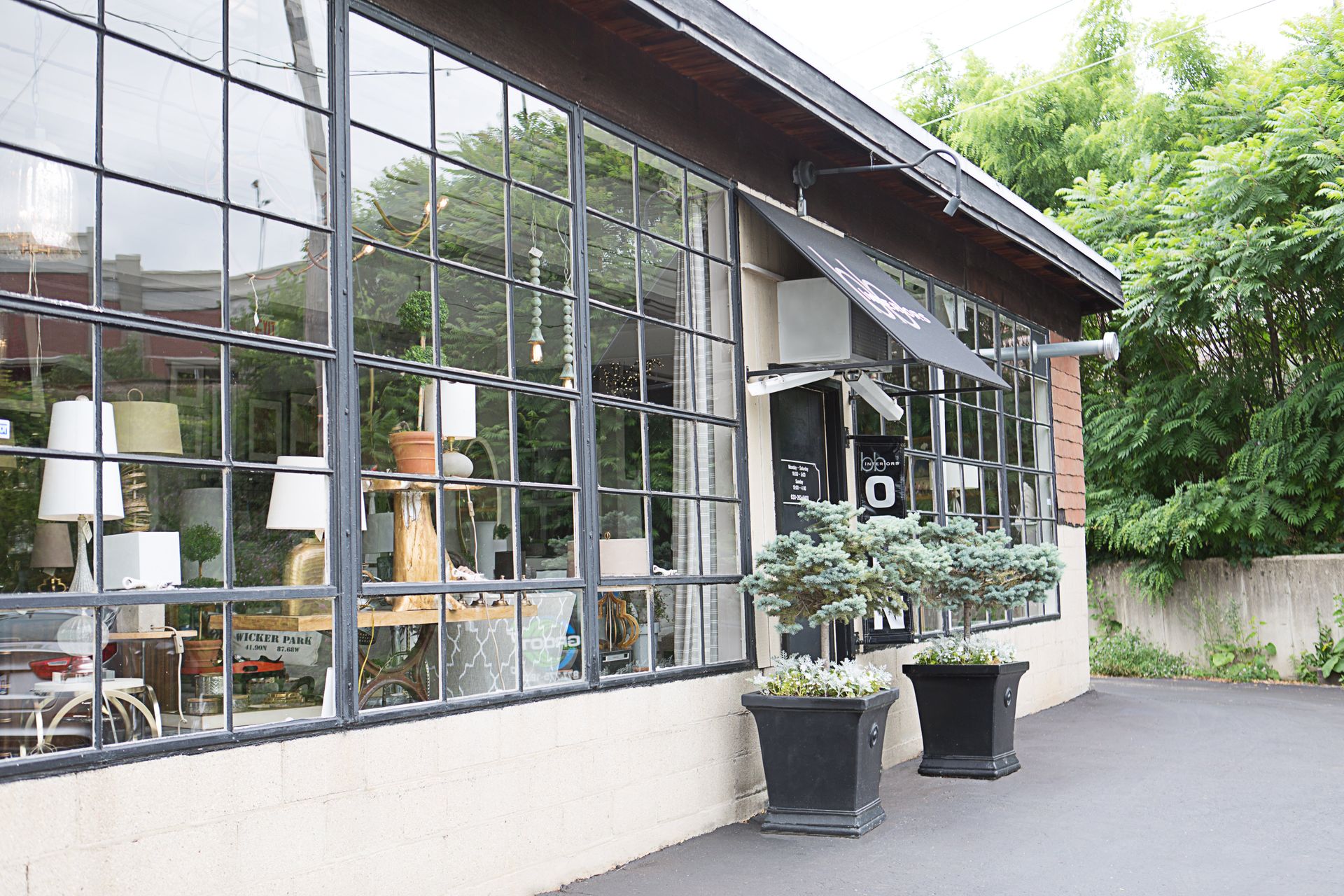 A building with a lot of windows and potted plants in front of it