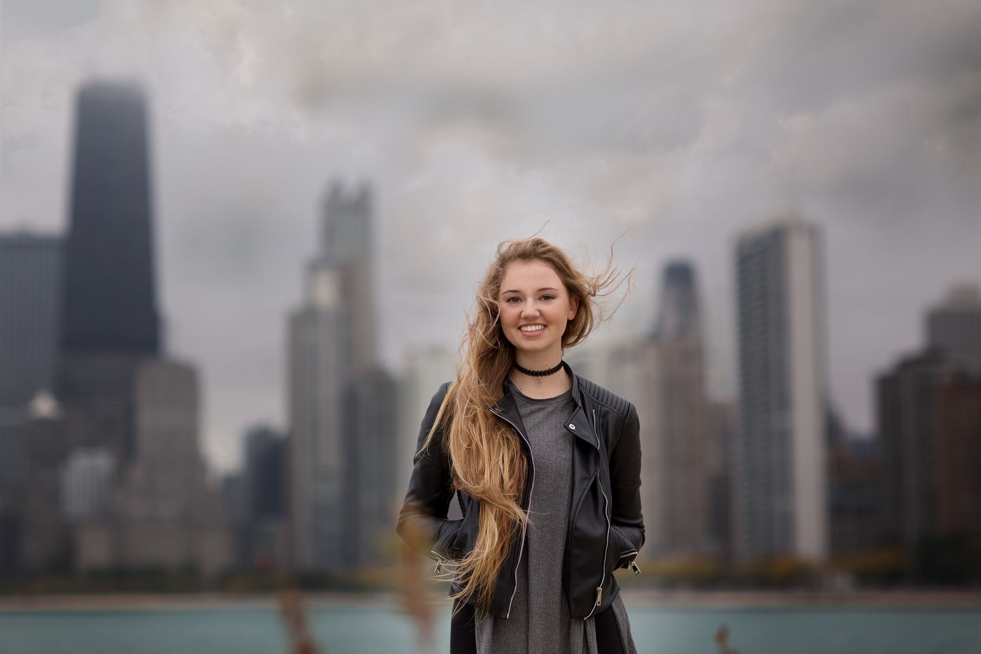 A woman is standing in front of a city skyline.