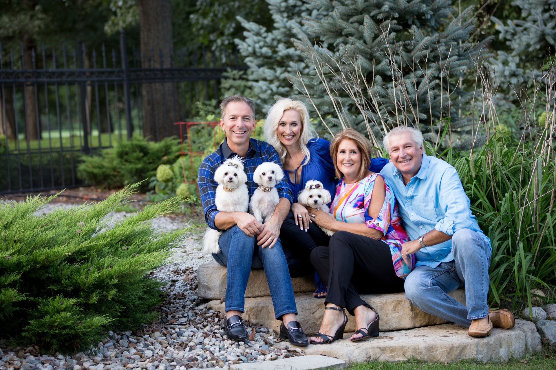 A group of people are posing for a picture with their dogs.