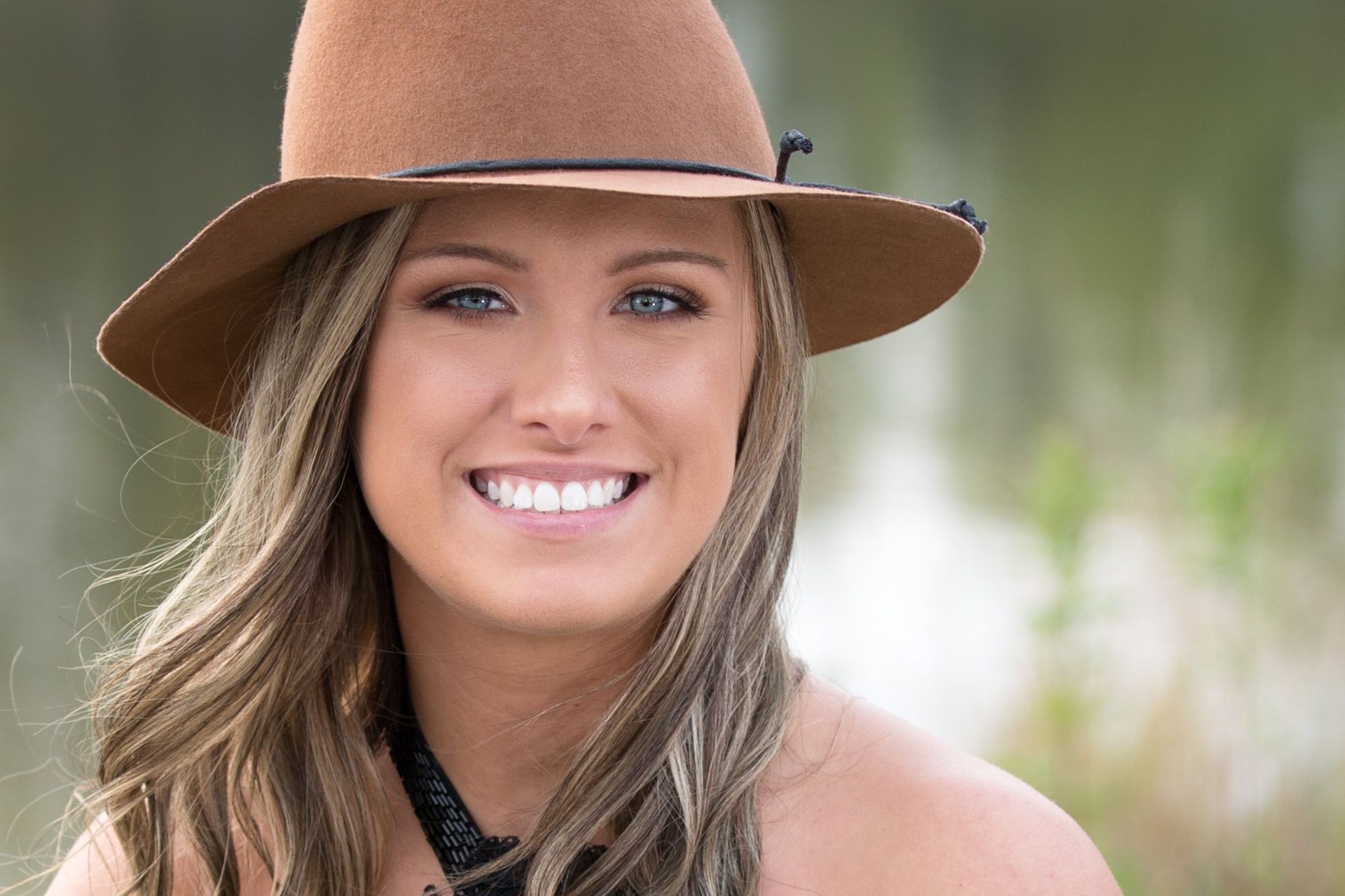 A woman wearing a hat is smiling for the camera.
