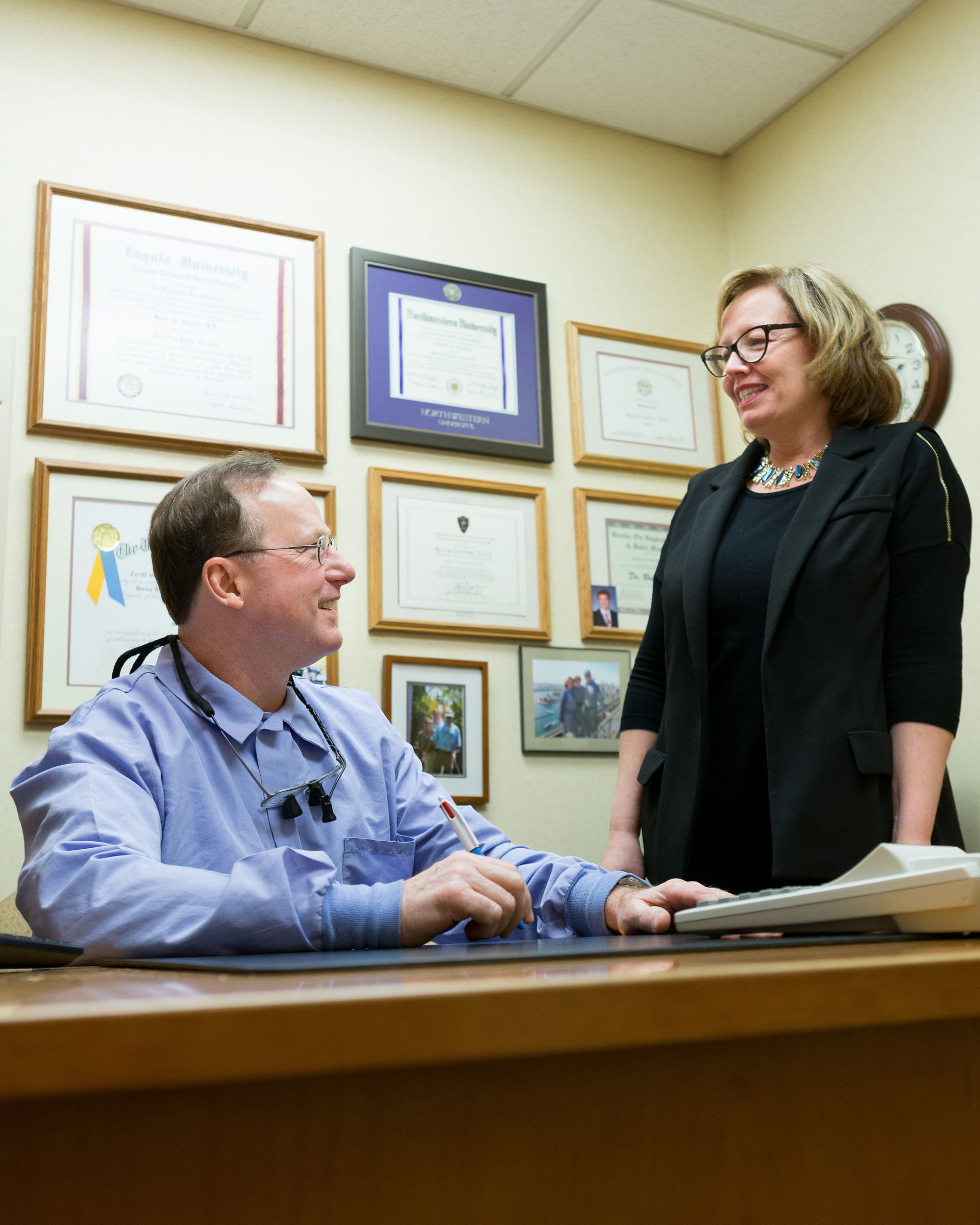 A man is sitting at a desk talking to a woman