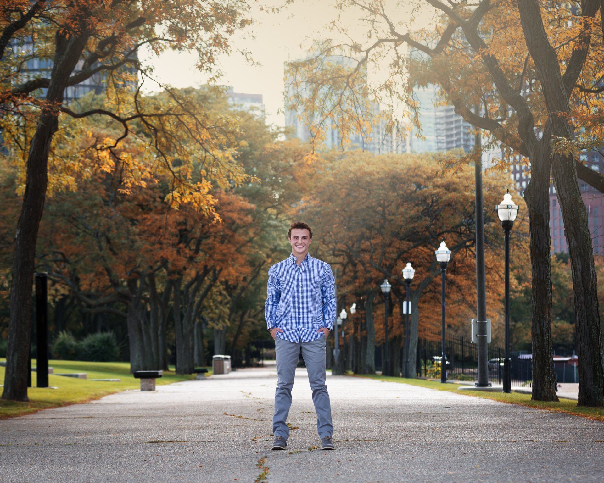 A man in a blue shirt is standing in a park