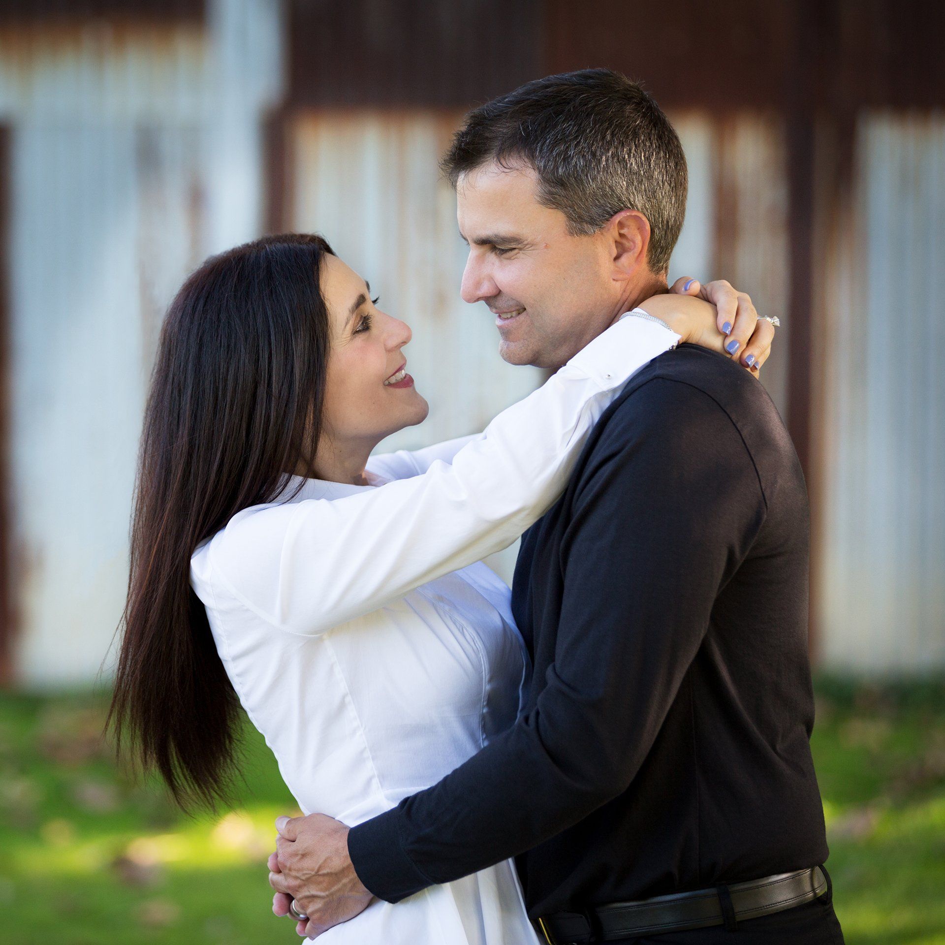 A man and a woman are hugging and looking at each other