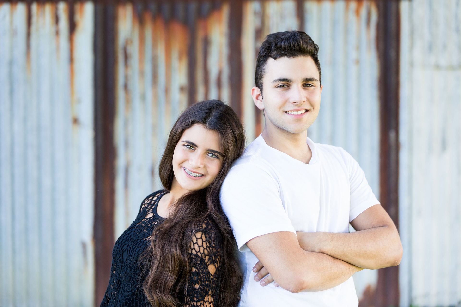 A man and a woman are standing next to each other with their arms crossed.