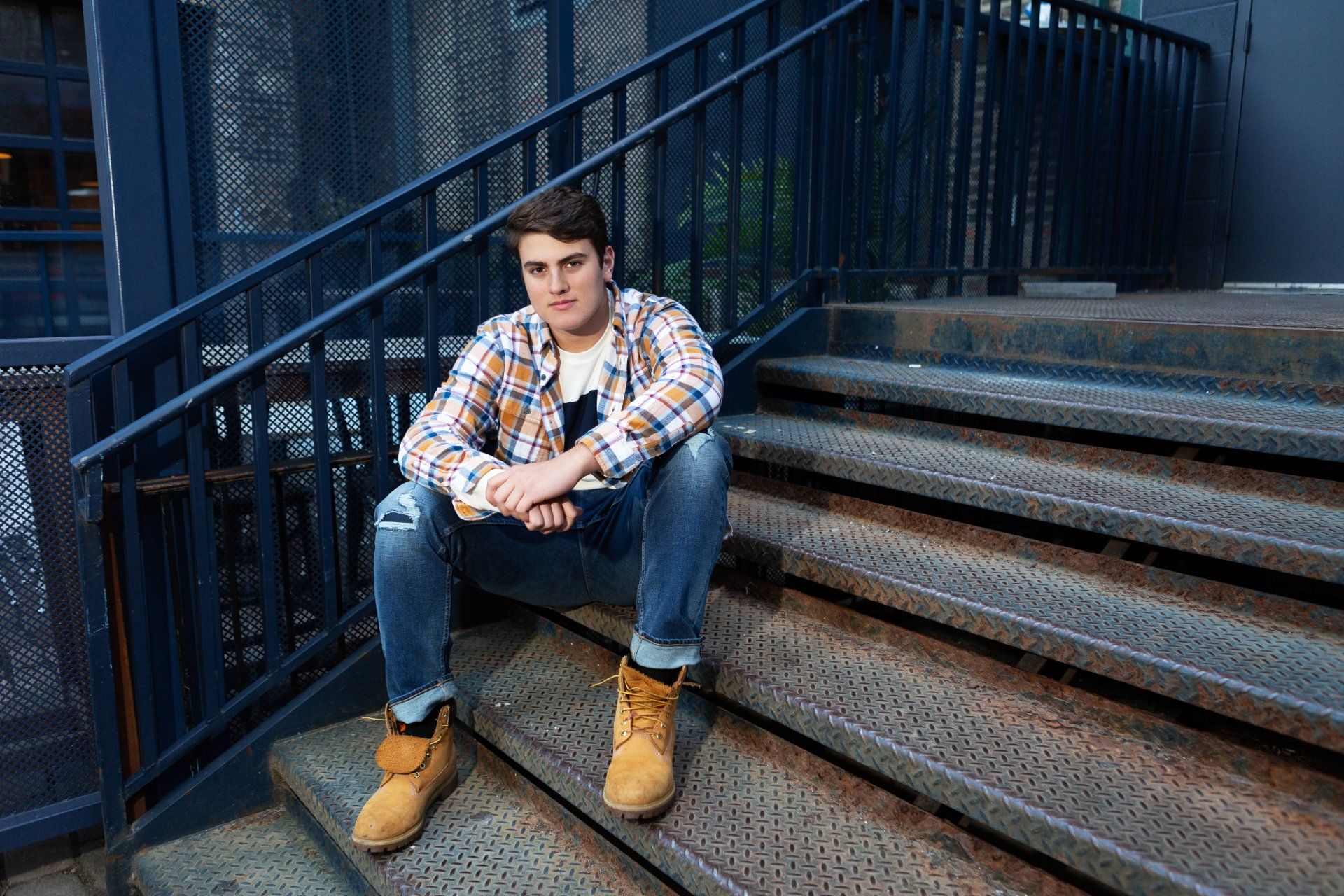 A young man is sitting on a set of stairs.