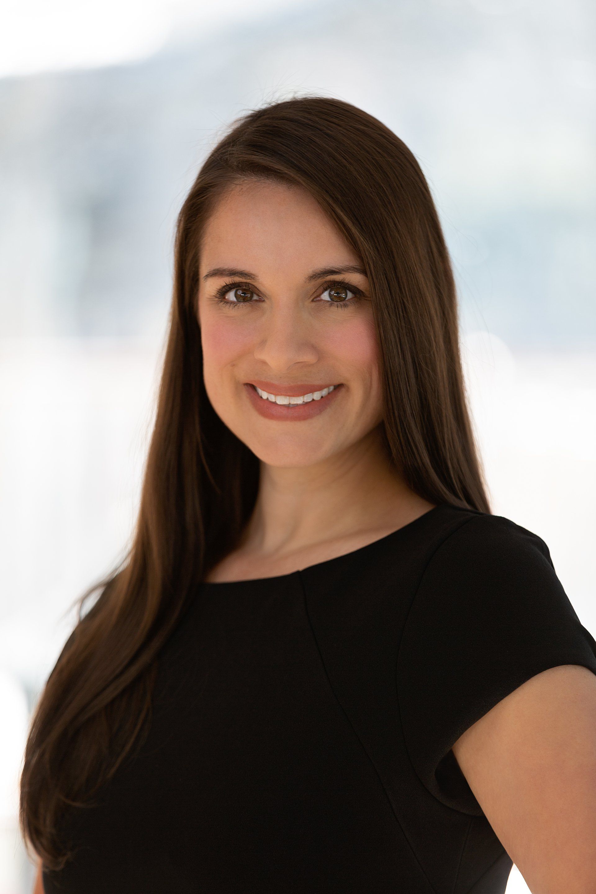 The woman is wearing a black shirt and smiling for the camera.