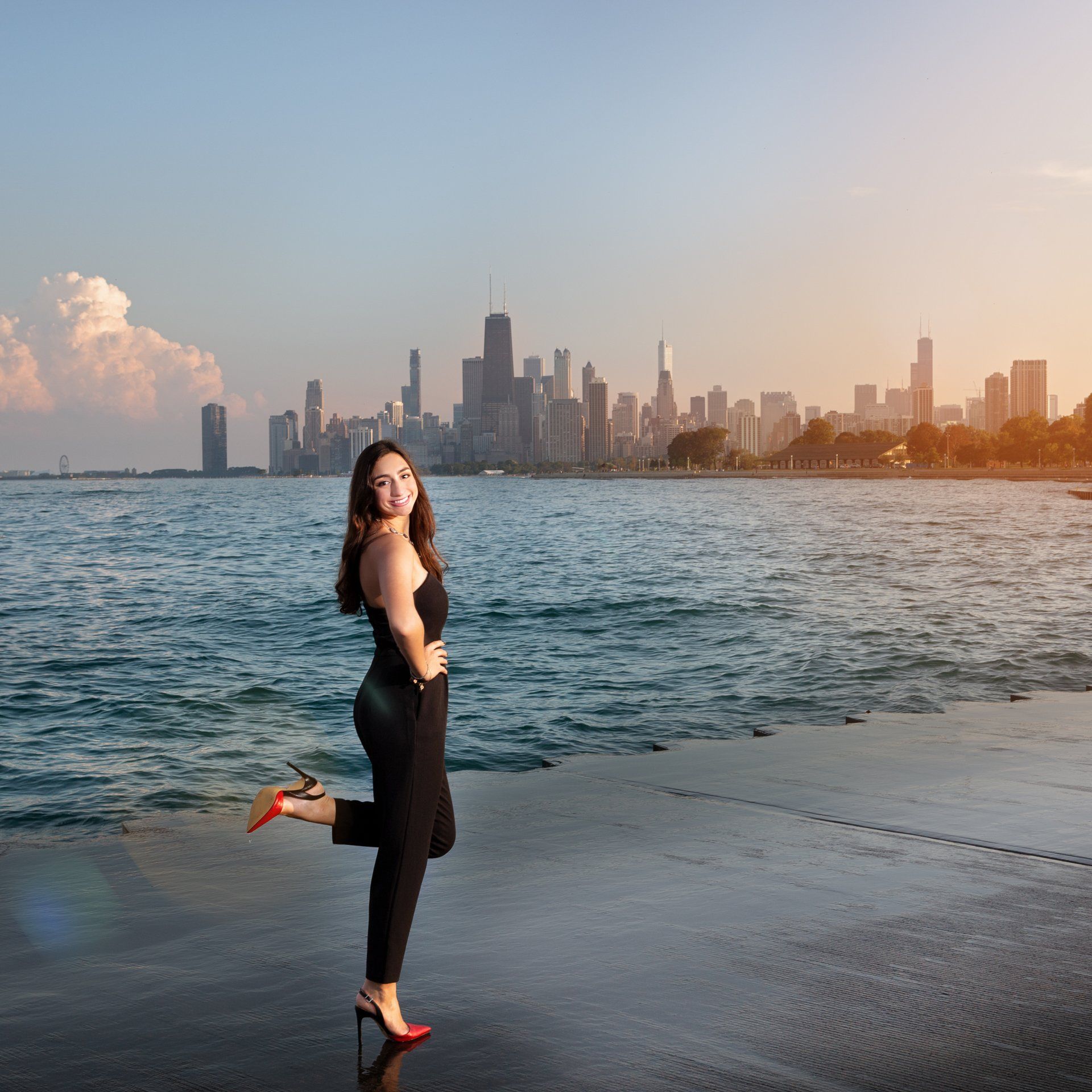A woman standing on a beach with a city skyline in the background