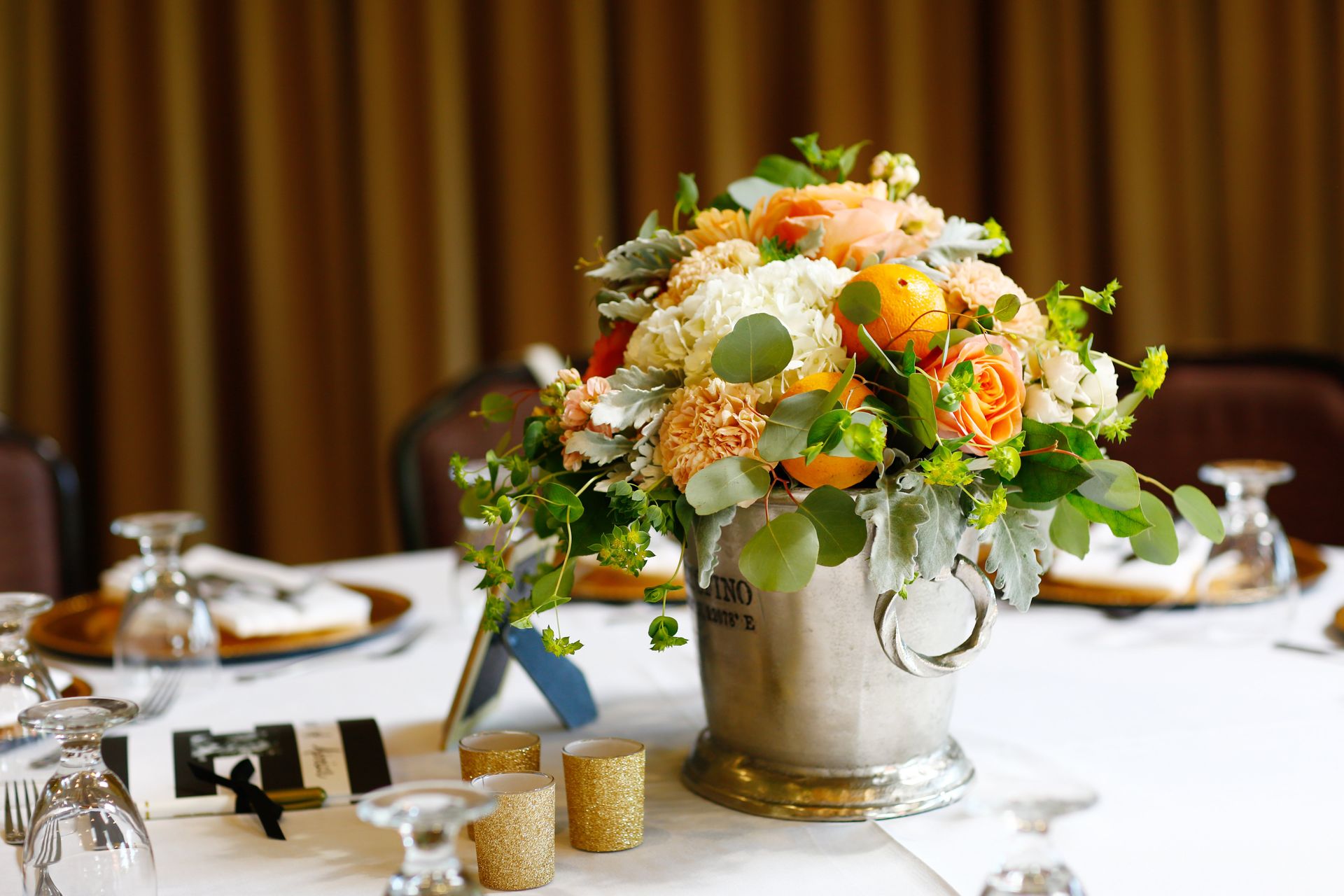 A bucket filled with flowers is sitting on a table.
